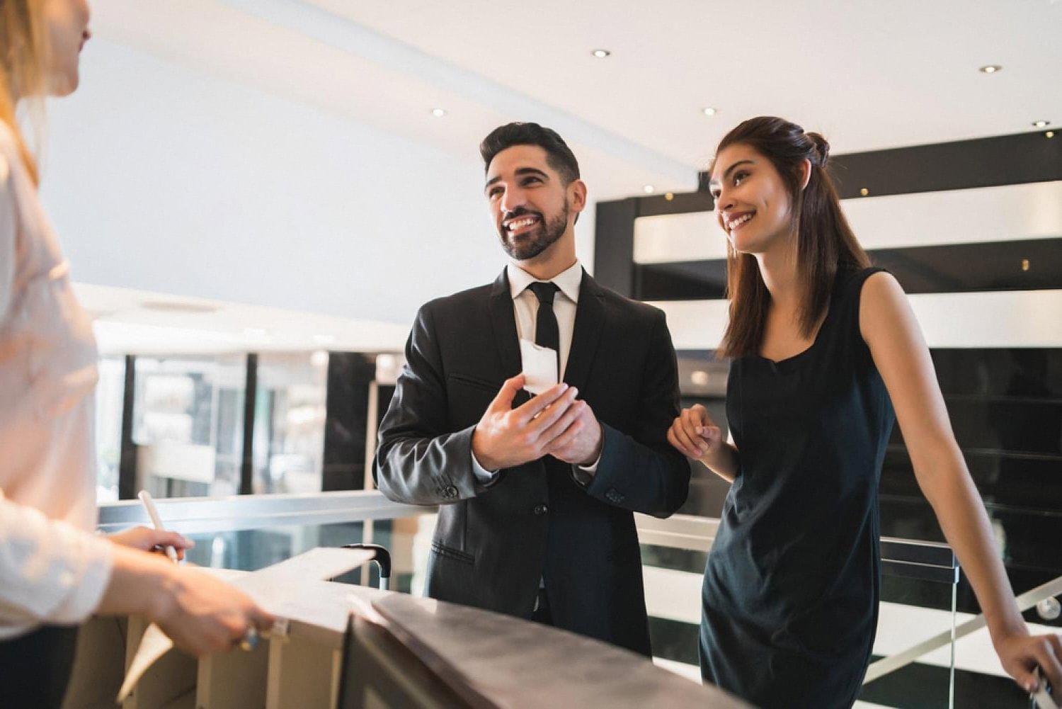 Couple checking into a US hotel while the receptionist processes their reservation in the PMS