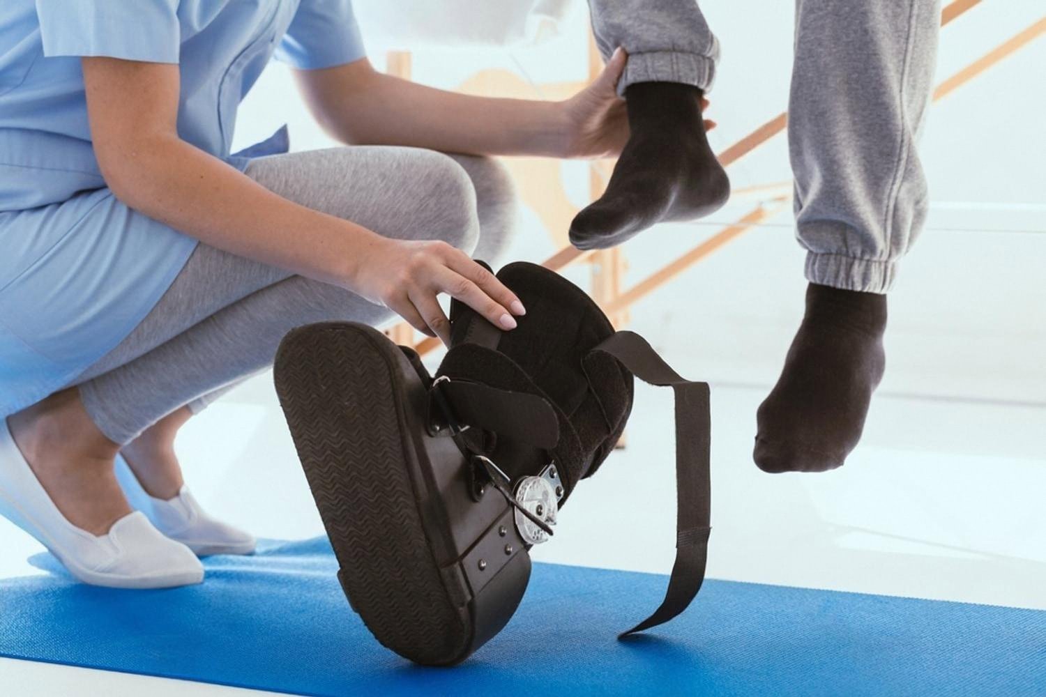 Physiotherapist fitting an orthopaedic boot on a patient at a UAE rehabilitation clinic